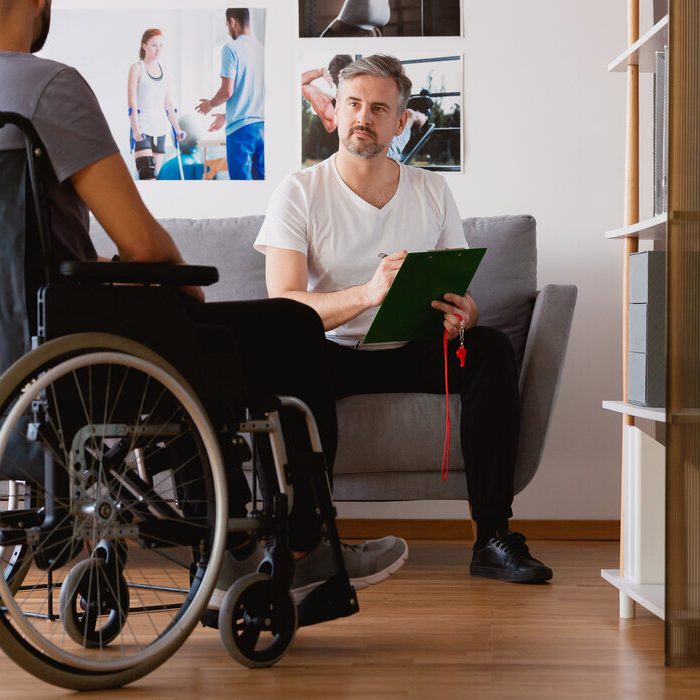 Physiotherapist planning taining for a man on wheelchair